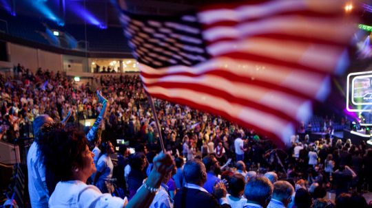 Mideast Israel Christian Allies In this photo taken Sept. 29, 2015, an Evangelical Christian holds up an American. flag during a gathering in Jerusalem. Thousands of evangelical Christians from more than 80 countries descended upon Jerusalem this week to show their support for the Jewish state, including pilgrims and politicians from countries with a history of hostility toward Israel. (AP Photo/Dan Balilty)