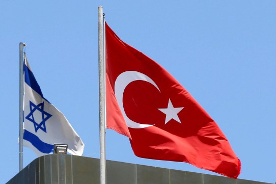 A Turkish flag flutters atop the Turkish embassy as an Israeli flag is seen nearby, in Tel Aviv, Israel